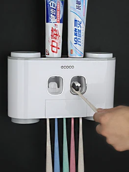 Automātiskā vannas istaba zobu pastai, dozators, zobu pasta squeezer, kas piestiprināts pie sienas turot zobu suka